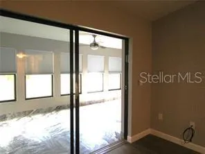 a view of an empty room with a window and a kitchen