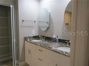 a bathroom with a granite countertop mirror and a sink