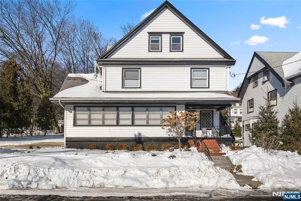a front view of a house with a yard covered in snow