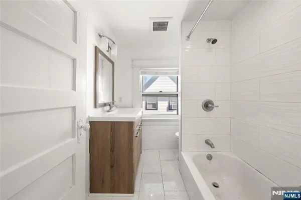 a bathroom with a bathtub sink and mirror