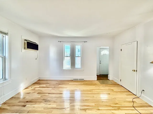 a view of an empty room with window and bathroom