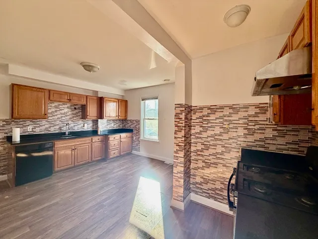 a kitchen with stainless steel appliances kitchen island granite countertop a stove and cabinets