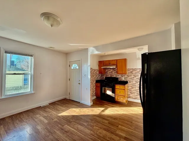 a view of a livingroom with a kitchen space and a window