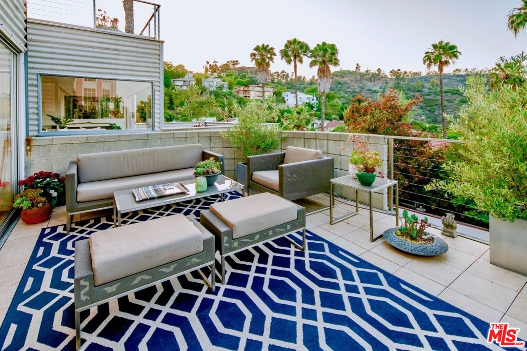 3711 Prestwick Drive Los Angeles, CA 90027 - Photo 14 of 37 a roof deck with a dining table and chairs with potted plants