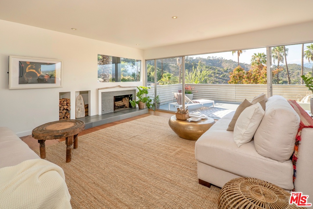 3711 Prestwick Drive Los Angeles, CA 90027 - Photo 4 of 37 a living room with furniture a fireplace and a floor to ceiling window
