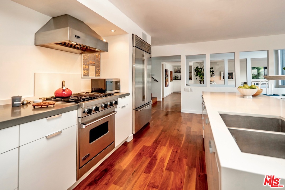 3711 Prestwick Drive Los Angeles, CA 90027 - Photo 9 of 37 a kitchen with stainless steel appliances a stove top oven and cabinets