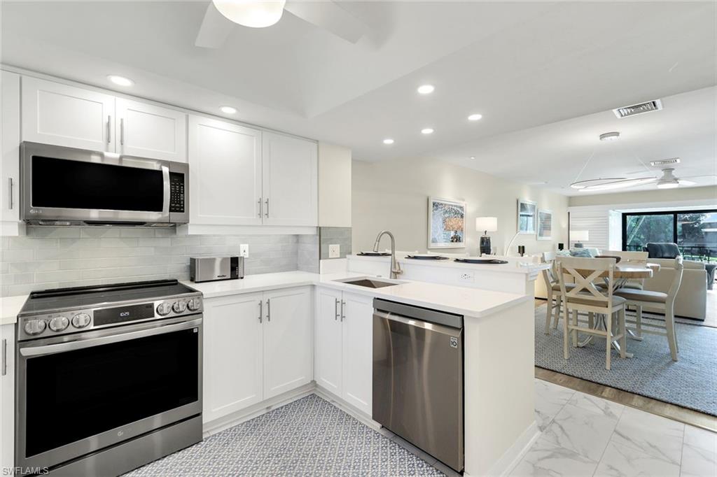 1672 Spoonbill Lane, Unit B Naples, FL 34105 - Photo 1 of 41 a kitchen with a sink stove and microwave