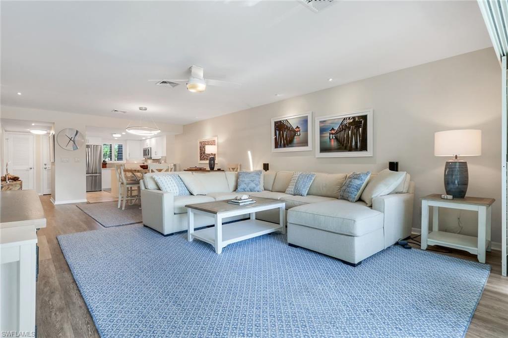 1672 Spoonbill Lane, Unit B Naples, FL 34105 - Photo 11 of 41 a living room with furniture and a chandelier