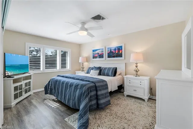 a spacious bedroom with a bed and a flat screen tv