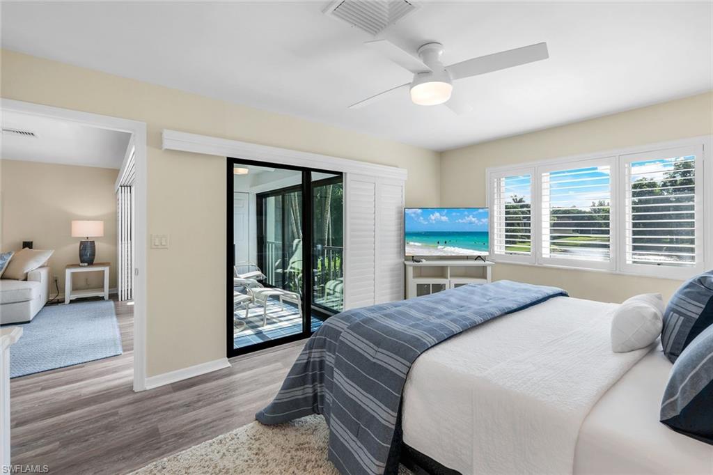 1672 Spoonbill Lane, Unit B Naples, FL 34105 - Photo 15 of 41 a bedroom with a bed and a large window