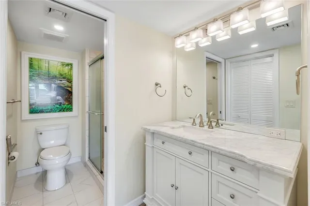 a bathroom with a granite countertop sink a toilet and a large mirror