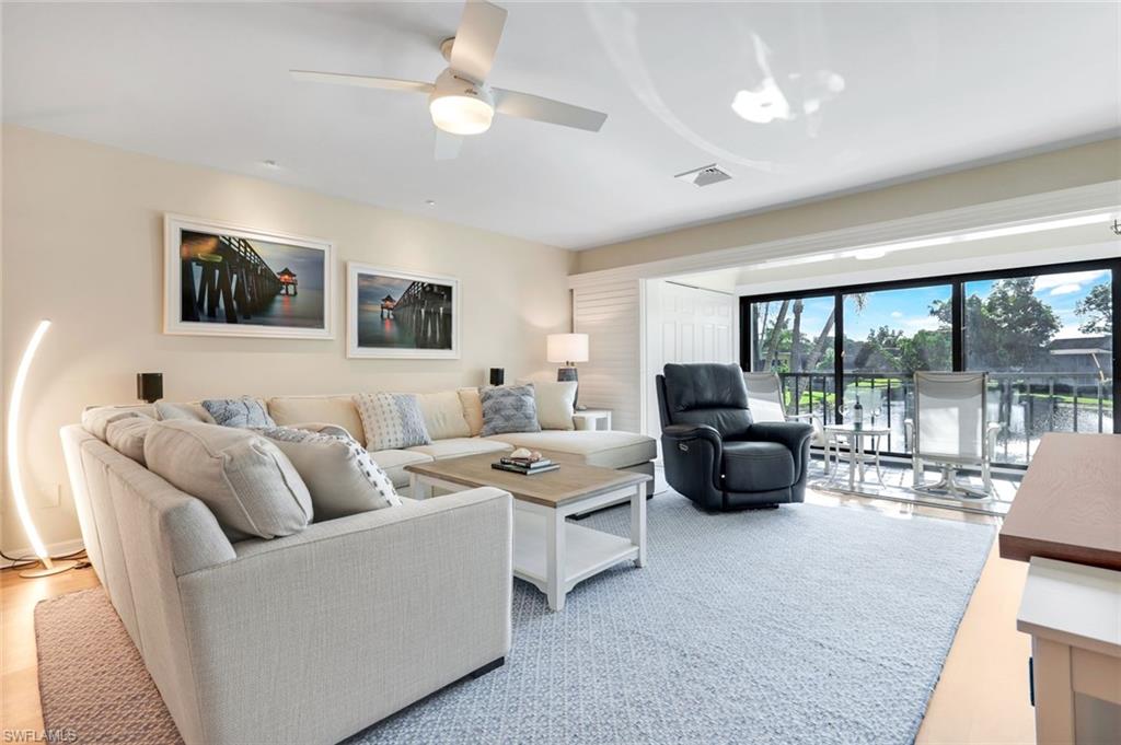 1672 Spoonbill Lane, Unit B Naples, FL 34105 - Photo 2 of 41 a living room with furniture and a flat screen tv