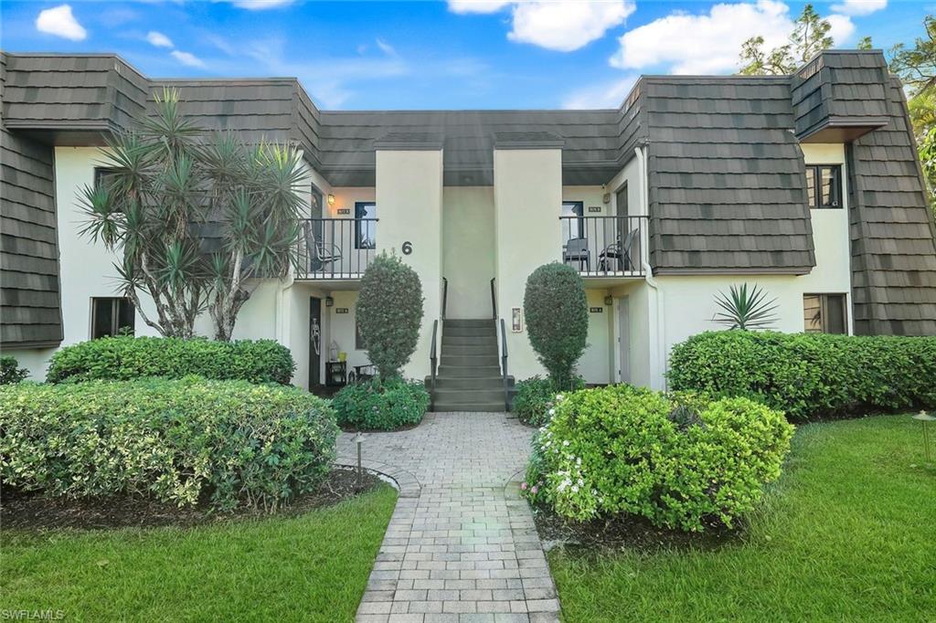 1672 Spoonbill Lane, Unit B Naples, FL 34105 - Photo 3 of 41 a view of a brick house with a yard