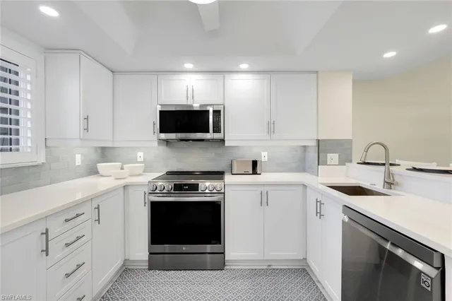 a kitchen with white cabinets and stainless steel appliances