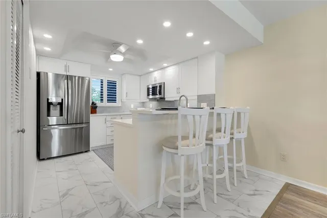 a kitchen with stainless steel appliances granite countertop a refrigerator and a stove top oven