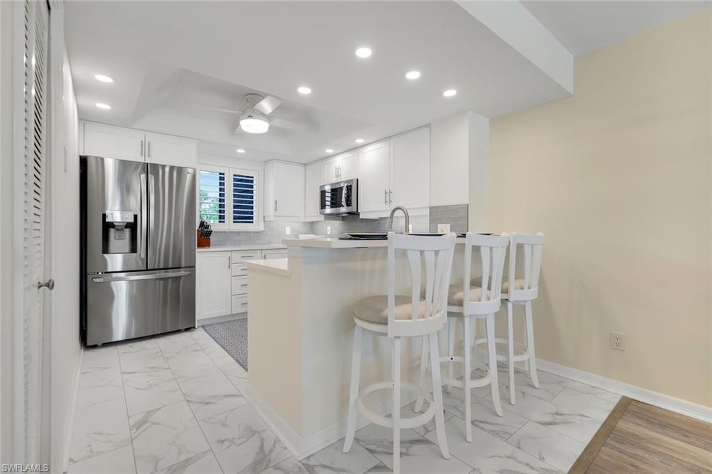 1672 Spoonbill Lane, Unit B Naples, FL 34105 - Photo 6 of 41 a kitchen with stainless steel appliances granite countertop a refrigerator and a stove top oven