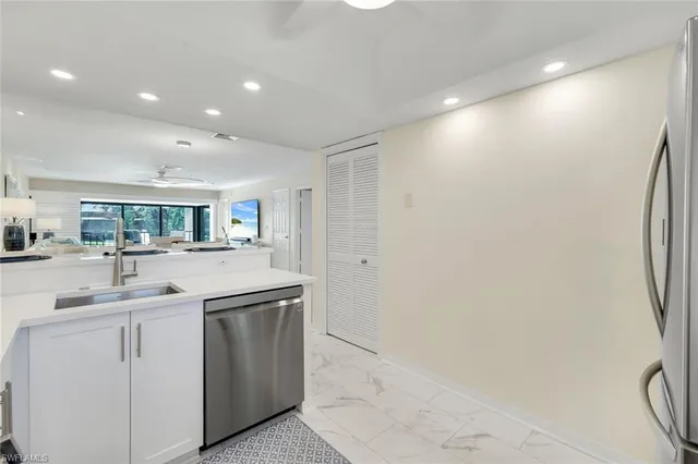a kitchen with white cabinets and sink
