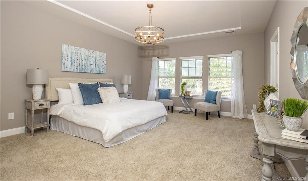 1026 Emory Lane Fort Mill, SC 29708 - Photo 15 of 41 a spacious bedroom with a bed and a chandelier