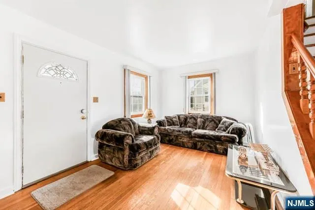 a living room with furniture and stairs with wooden floor