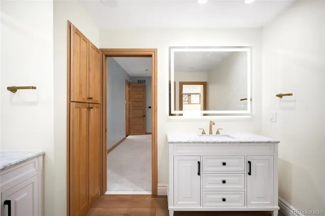 a bathroom with a granite countertop sink and a mirror