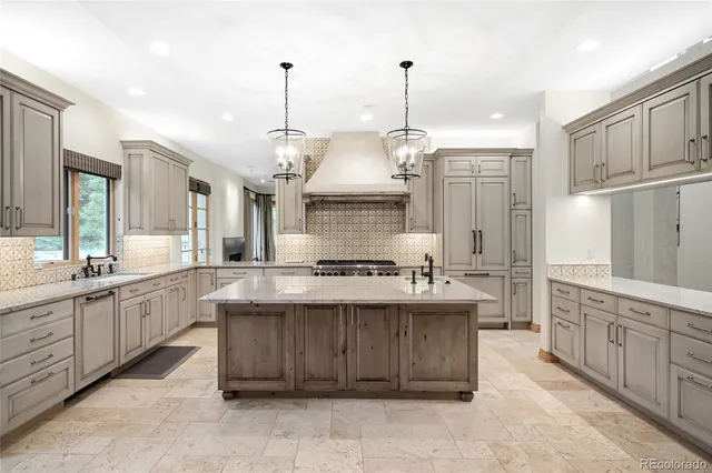 a large white kitchen with kitchen island a sink stainless steel appliances and cabinets