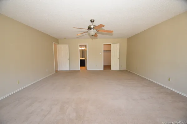 an empty room with a ceiling fan and a window