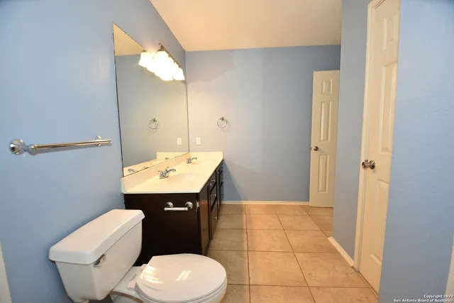 a bathroom with a toilet sink and mirror