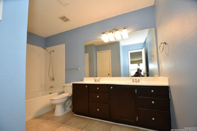 a bathroom with a double vanity sink mirror and toilet