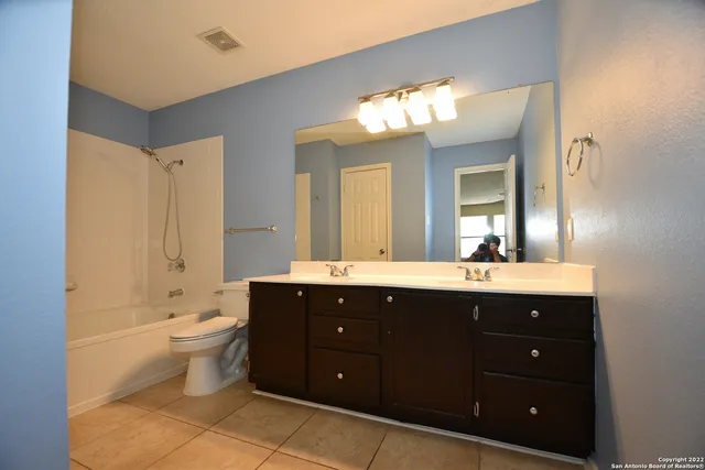 a spacious bathroom with a double vanity sink toilet and a tub