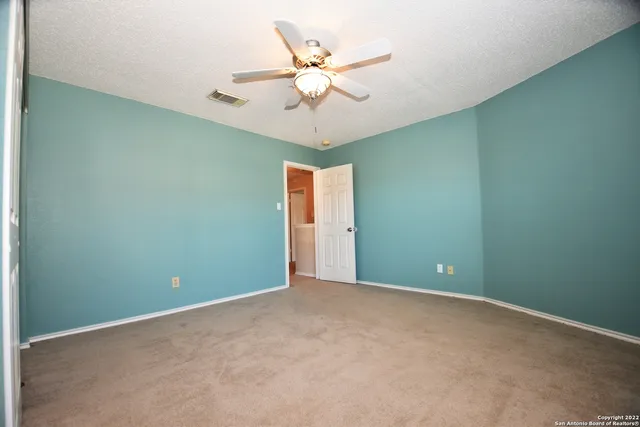 an empty room and a ceiling fan with a window