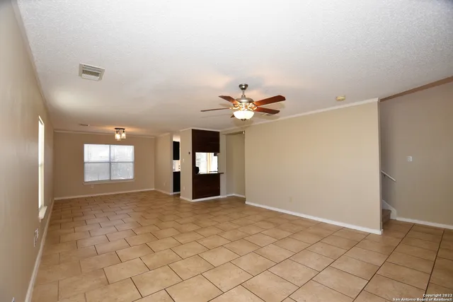 a view of a livingroom with a chandelier fan and windows