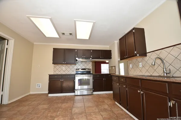 a large kitchen with stainless steel appliances granite countertop a refrigerator and a sink