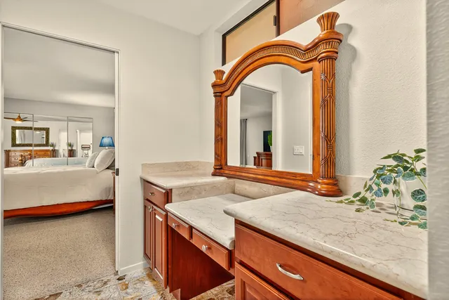 a en suite bathroom with a granite countertop sink and a mirror