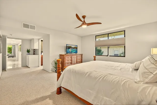 a bedroom with a bed and a large mirror