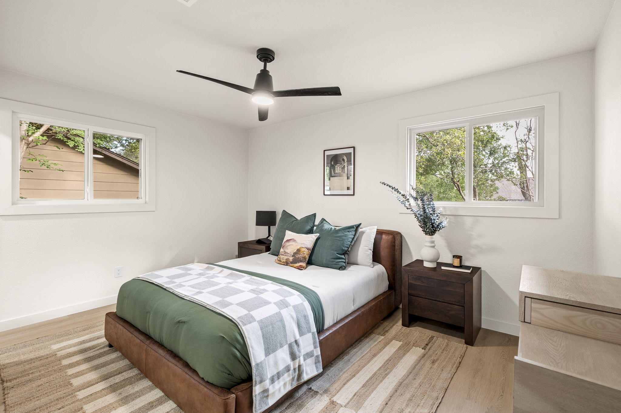 2107 Cindy Lane Austin, TX 78727 - Photo 19 of 33 Bright bedroom with two large windows, a ceiling fan with integrated lighting, LVP flooring and new baseboards