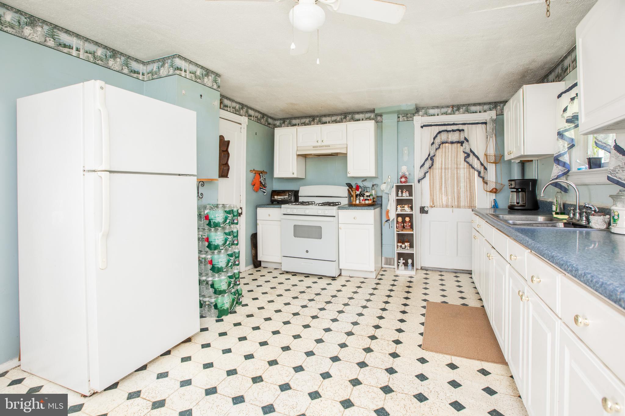 752 Groveville Road Hamilton, NJ 08620 - Photo 12 of 33 a kitchen with granite countertop a refrigerator a sink and white cabinets
