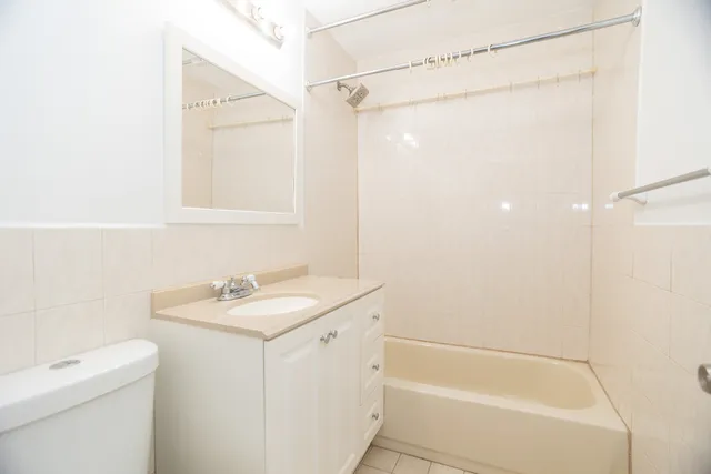 a bathroom with a granite countertop sink a toilet and shower