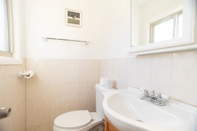 a bathroom with a sink mirror and toilet