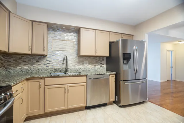 a kitchen with stainless steel appliances granite countertop a refrigerator sink and cabinets