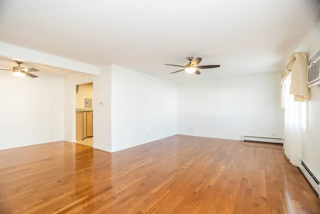 a view of a room with wooden floor and a ceiling fan