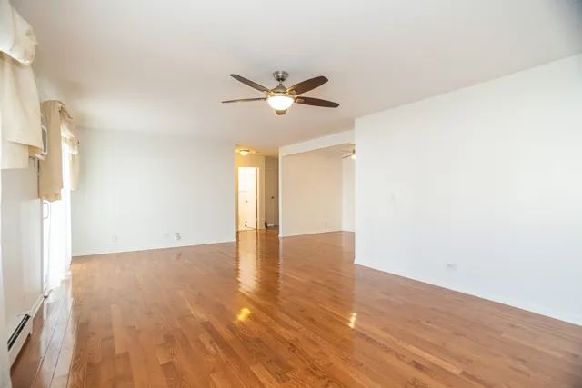 a view of an empty room with wooden floor