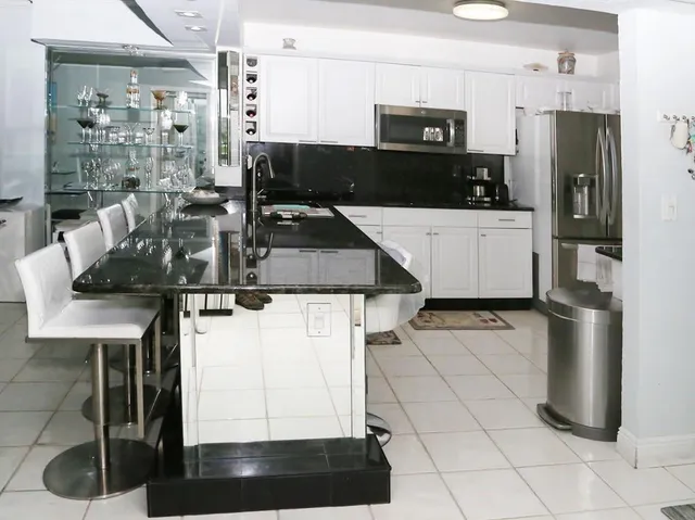 a kitchen with granite countertop a table chairs stove and cabinets