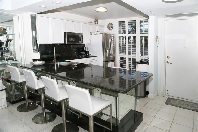 a dining hall with stainless steel appliances a table and chairs