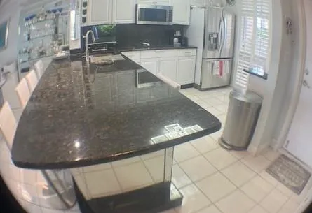 a kitchen with stainless steel appliances kitchen island granite countertop a refrigerator a stove a sink and a counter top space