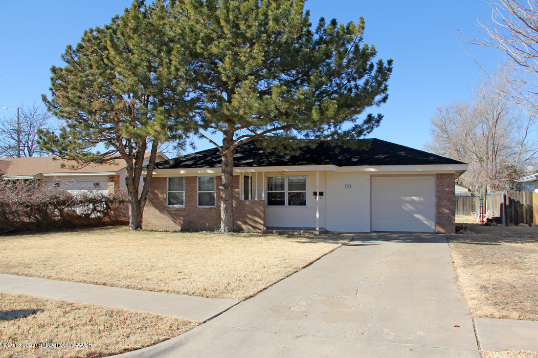a front view of a house with a yard covered with snow