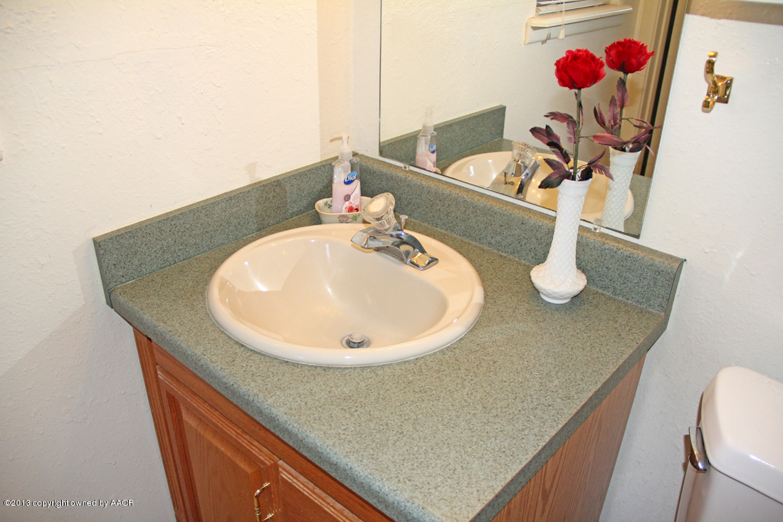 5324 Allen Street Amarillo, TX 79110 - Photo 13 of 24 a bathroom with a sink a toilet and mirror