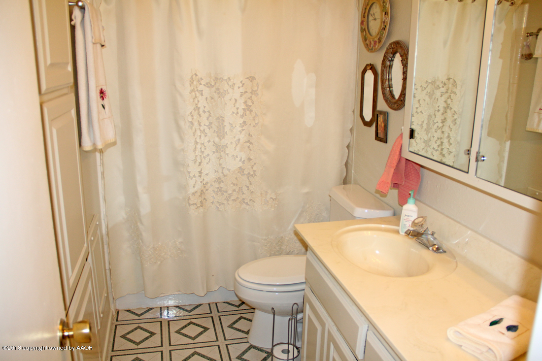 5324 Allen Street Amarillo, TX 79110 - Photo 16 of 24 a bathroom with a sink a toilet and a mirror