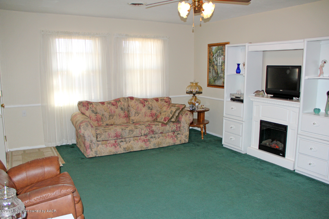 5324 Allen Street Amarillo, TX 79110 - Photo 5 of 24 a living room with furniture a flat screen tv and a fireplace