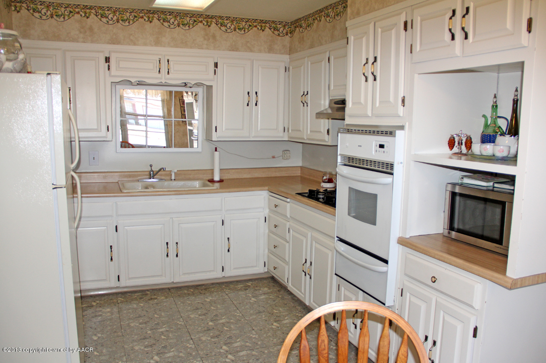 5324 Allen Street Amarillo, TX 79110 - Photo 6 of 24 a kitchen with granite countertop white cabinets and white appliances