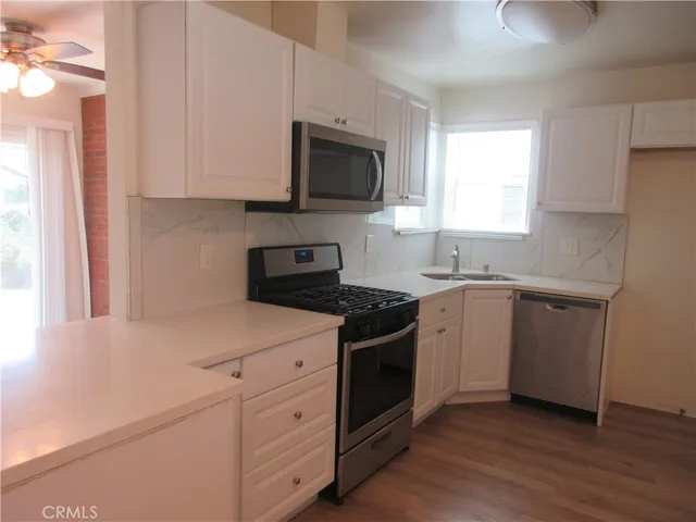 a kitchen with stainless steel appliances granite countertop a sink a stove a microwave and cabinets